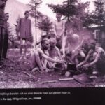 Arie Leib Žabner (zweiter von links) mit einer Gruppe von Überlebenden am Lagerfeuer nach der Befreiung, Ebensee, 8. Mai 1945.